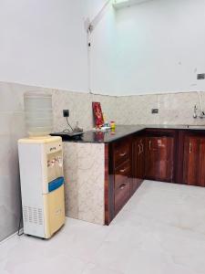 a kitchen with a counter and a refrigerator at Nirmal sadan Homestay in Kāman
