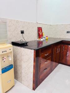 a kitchen with a counter top and a refrigerator at Nirmal sadan Homestay in Kāman