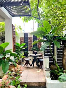 eine Terrasse mit Tischen, Stühlen und Pflanzen in der Unterkunft Yotaka Boutique Hotel Bangkok in Bangkok