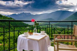 a table with a book and a vase of flowers on a balcony at To Kallion in Klávsion