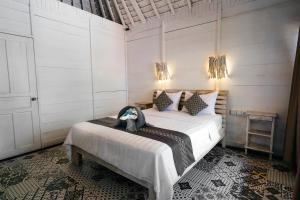 a bedroom with a bed in a room with lights at Easy Surf Camp in Kuta