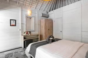 a bedroom with white walls and a bed in a room at Easy Surf Camp in Kuta