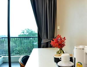 a table with a vase of flowers and a window at NORN Canalside Bangkok Hotel โรงแรมนอนริมคลอง in Bangkok Noi