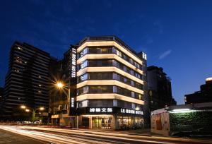 a tall building on a city street at night at 綺樂文旅 康定館 Le Room Hotel Kangding in Taipei