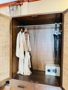 Zimmer mit einem Schrank, einer Mikrowelle und Sonnenschirmen in der Unterkunft Yotaka Boutique Hotel Bangkok in Bangkok