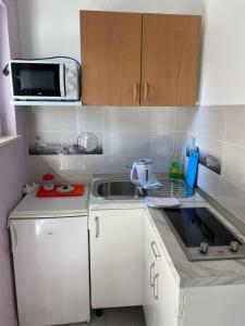 een kleine keuken met een wastafel en een magnetron bij Koko in Split