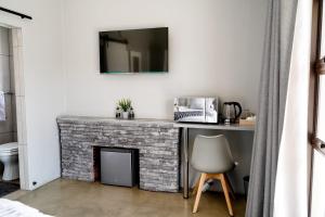 uma sala de estar com uma lareira de tijolos e um espelho em Alu Boutique Hotel and Conference em Roodepoort