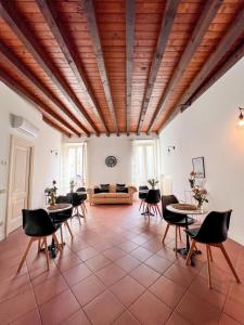 ein Wohnzimmer mit Tischen, Stühlen und einem Sofa in der Unterkunft Il Cantuccio di Gioia in Brescia