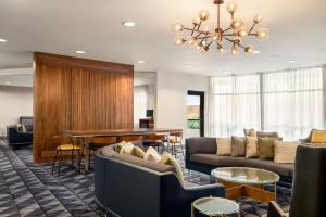 a living room with couches and tables and a chandelier at Courtyard by Marriott Columbia in Columbia
