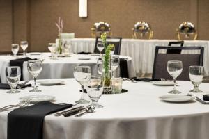 um grupo de mesas com toalhas de mesa brancas e copos de vinho em Courtyard by Marriott Columbia em Columbia