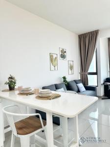 uma mesa branca e cadeiras numa sala de estar em Bali Residences Sea View Suites Melaka em Malaca