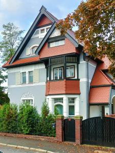 une grande maison blanche avec un toit rouge dans l'établissement Villa Ley, à Jelenia Góra
