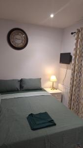 a bedroom with a bed with a clock on the wall at Deluxe Single room only for one adult in Northolt