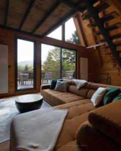 ein Wohnzimmer mit einem Sofa, einem Tisch und Fenstern in der Unterkunft forest angel rg in Ravna Gora