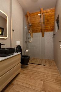 a bathroom with a black toilet and a sink at forest angel rg in Ravna Gora