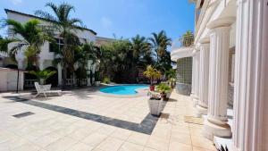 a house with a swimming pool in a yard at HomeVilla in Brusubi