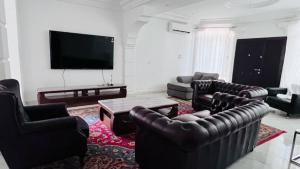 a living room with leather furniture and a flat screen tv at HomeVilla in Brusubi