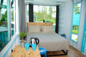 1 dormitorio con 1 cama con tazas azules sobre una mesa en Sarang by the brook en Kuala Kubu Baharu