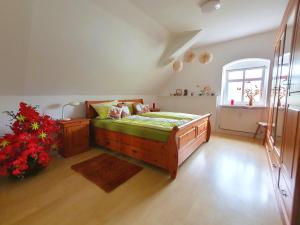een slaapkamer met een bed en bloemen in een kamer bij Rittergut Dornreichenbach 