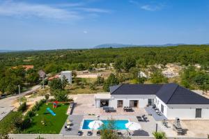 an aerial view of a house with a pool and a yard at NEW! Villa Lukas with 44m2 pool in Makarska hinterland in Gornji Vinjani