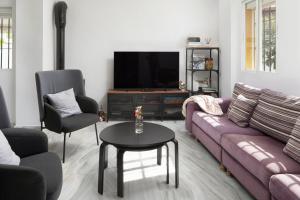 uma sala de estar com um sofá e uma televisão em Brisa del mar em Chilches