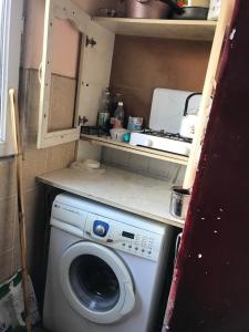 eine Waschmaschine in einem kleinen Zimmer mit einer Theke in der Unterkunft T7B hostel in Tbilisi City