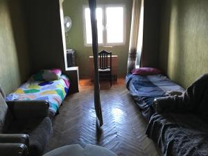 ein Wohnzimmer mit 2 Betten und einem Sofa in der Unterkunft T7B hostel in Tbilisi City