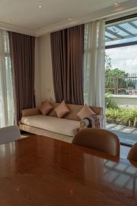 ein Wohnzimmer mit Sofa und Tisch in der Unterkunft View View Villas Hạ Long 6A01 - 8Br -Pool in Hạ Long