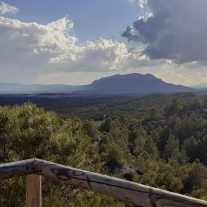 uma vista para as montanhas a partir de um corrimão de madeira em El Fuerte em Benamaurel