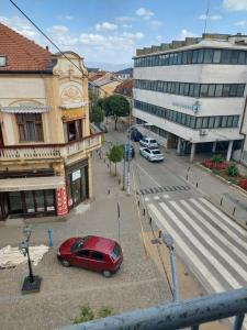 una macchina rossa parcheggiata in una strada in città di Apartman Uki a Vranje