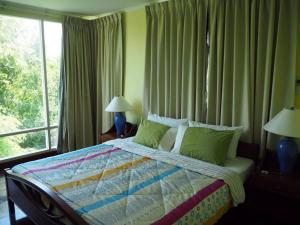 a bedroom with a bed with two lamps and a window at Baan Sanploen. Unit 244 in Hua Hin