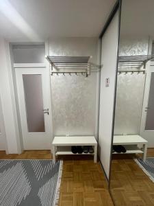ein Ankleidezimmer mit 2 Bänken und einem Spiegel in der Unterkunft SASE Apartment in Sarajevo