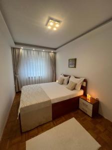 ein Schlafzimmer mit einem großen Bett und einem Fenster in der Unterkunft SASE Apartment in Sarajevo