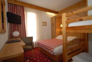 a bedroom with a bunk bed and a desk with a computer at Hôtel Le Sherpa Val Thorens in Val Thorens