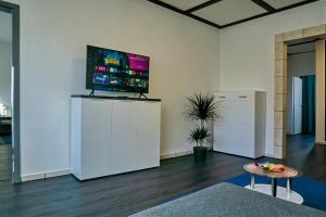 sala de estar con TV en una pared blanca en BIG Apartment bis 7 Personen, en Solingen