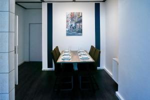 a dining room with a table with chairs and a painting at BIG Apartment bis 7 Personen in Solingen