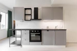 a kitchen with stainless steel appliances and white cabinets at Serviced Apartments Kuohu Kangasala by UHANDA in Kangasala
