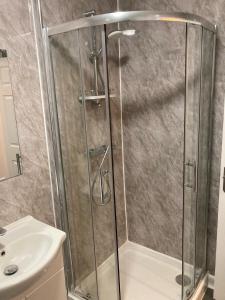 a shower with a glass door next to a sink at The Earlham Hotel in Norwich