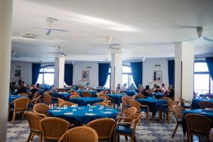 a group of people sitting at tables in a room at Villaggio La Marée in Pisciotta