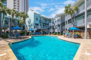 una piscina en el patio de un edificio de apartamentos en Steps to Sand l Ocean views l Smart TVs l Pool en Gulf Shores