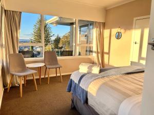 a hotel room with a bed and two chairs and a window at Tranquil mountain peak in Rotorua