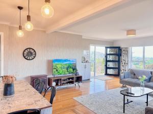 a living room with a tv and a table at Tranquil mountain peak in Rotorua