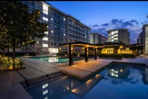a pool with a gazebo next to a building at The Narci Suites in Manila