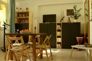 uma sala de estar com uma mesa e cadeiras e uma televisão em Casa Arcobaleno em Marsala