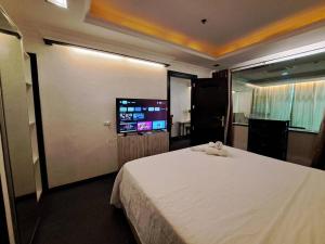 ein Schlafzimmer mit einem großen Bett und einem Flachbild-TV in der Unterkunft 1BR Fields Plaza Hotel 402 by ABC near to walking St in Angeles