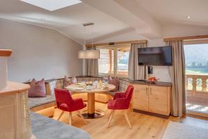 sala de estar con mesa y sillas rojas en Apparthotel Talhof, Restaurant, Pool und Spa en Oberau