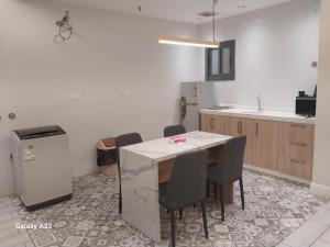 a kitchen with a table and chairs and a refrigerator at مكارم الدار in Makkah