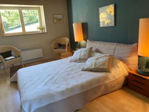 ein Schlafzimmer mit einem großen weißen Bett mit zwei Kissen in der Unterkunft Calme et tranquillité à la campagne in Charnay