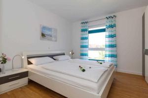 レリクにあるFerienwohnung Ostseebrise Rerikの大きな白いベッドと窓のある寝室