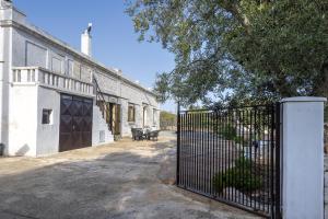 una valla frente a un edificio con un banco en La casa di pietra location Rosy, en Monopoli